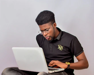 A man sitting on the floor using a laptop computer