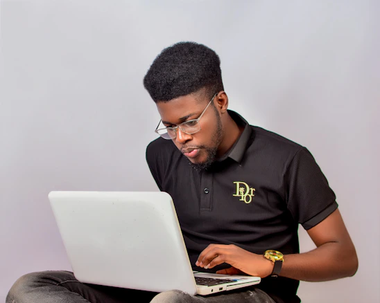 A man sitting on the floor using a laptop computer
