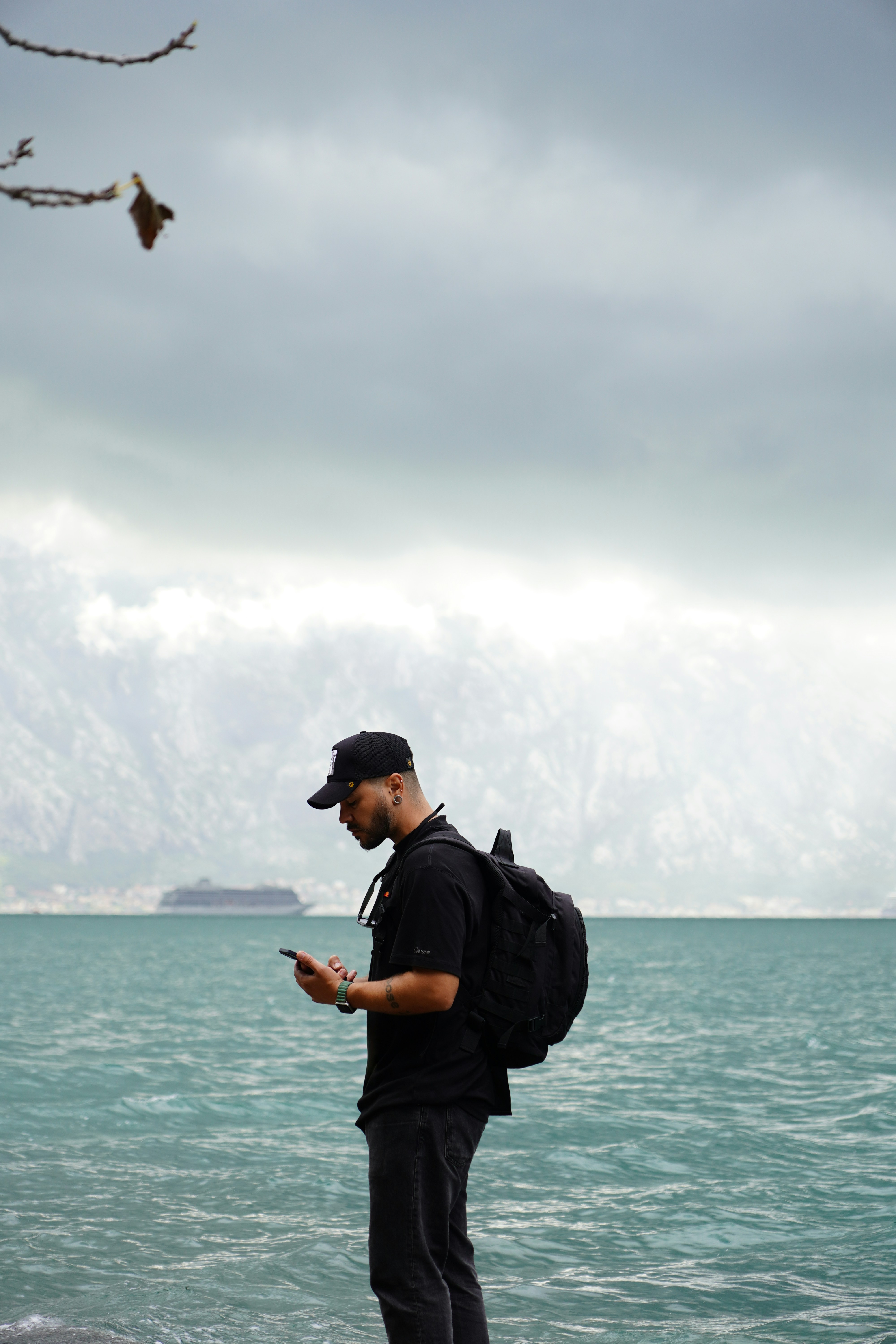 A man standing on a rock looking at his cell phone