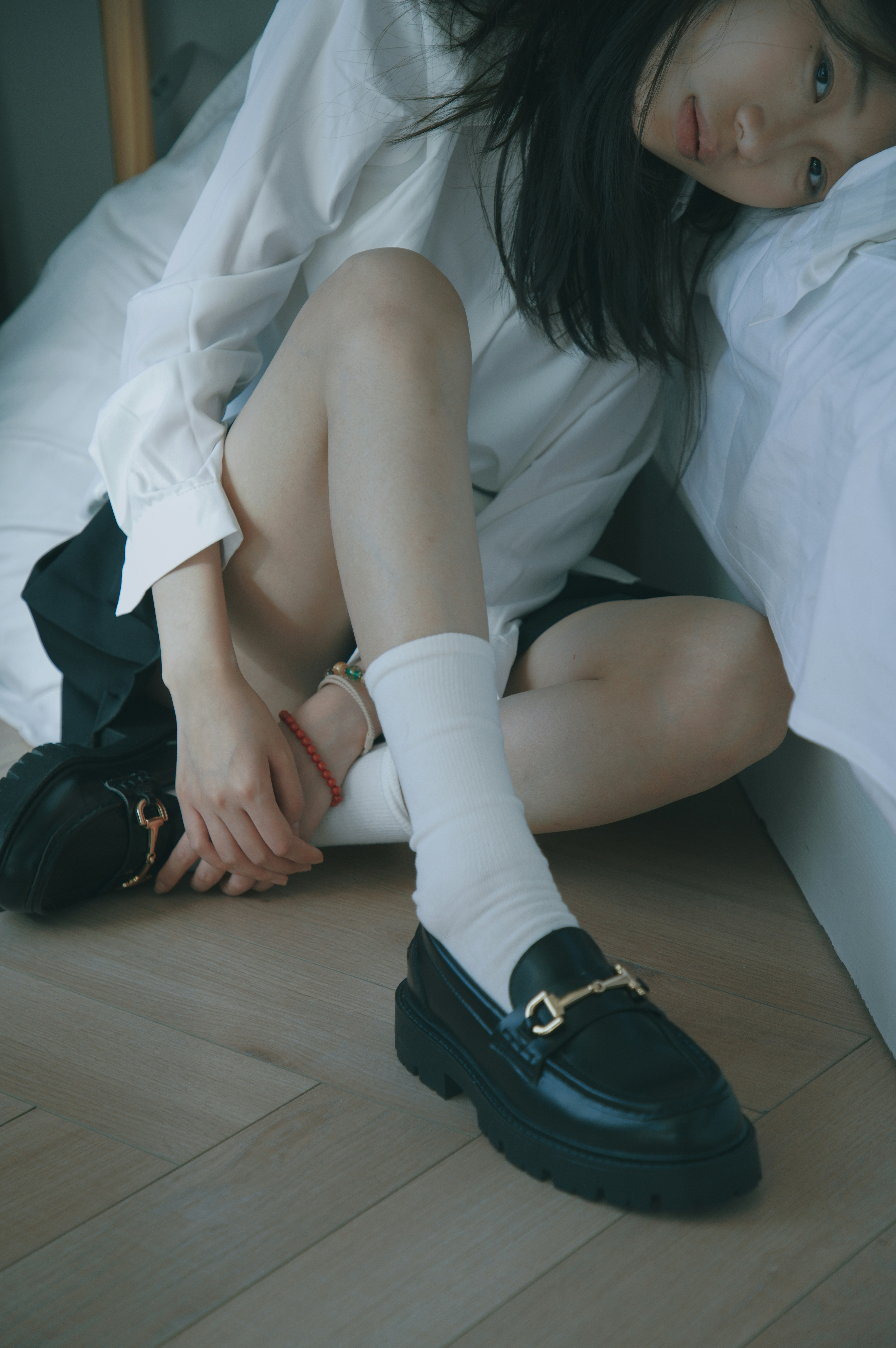 Une femme assise sur un lit portant des chaussures noires