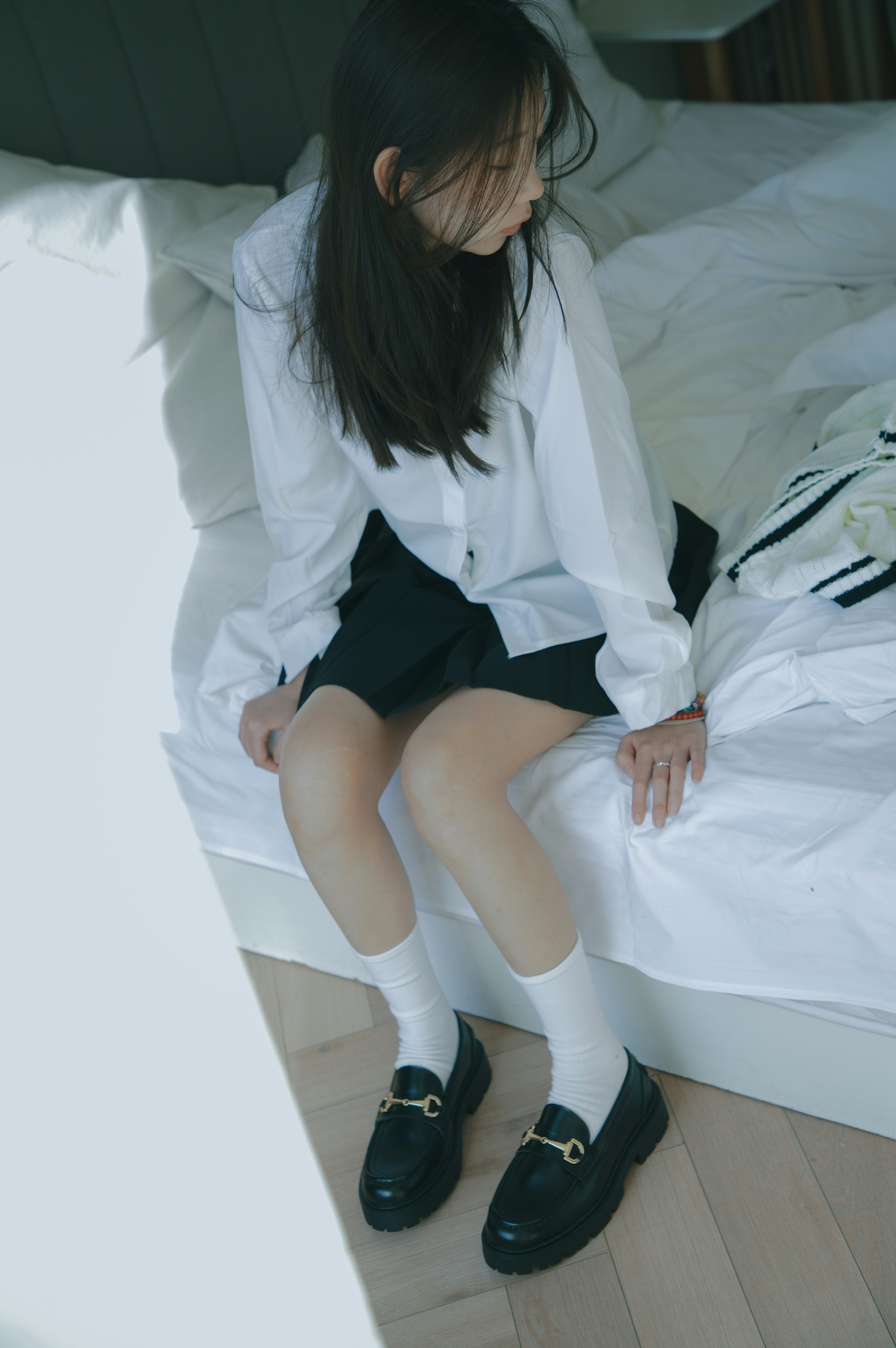 Une femme assise sur un lit avec des draps blancs