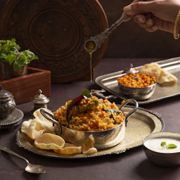 A person holding a spoon over a bowl of food