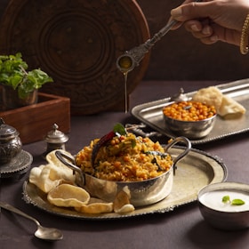 A person holding a spoon over a bowl of food