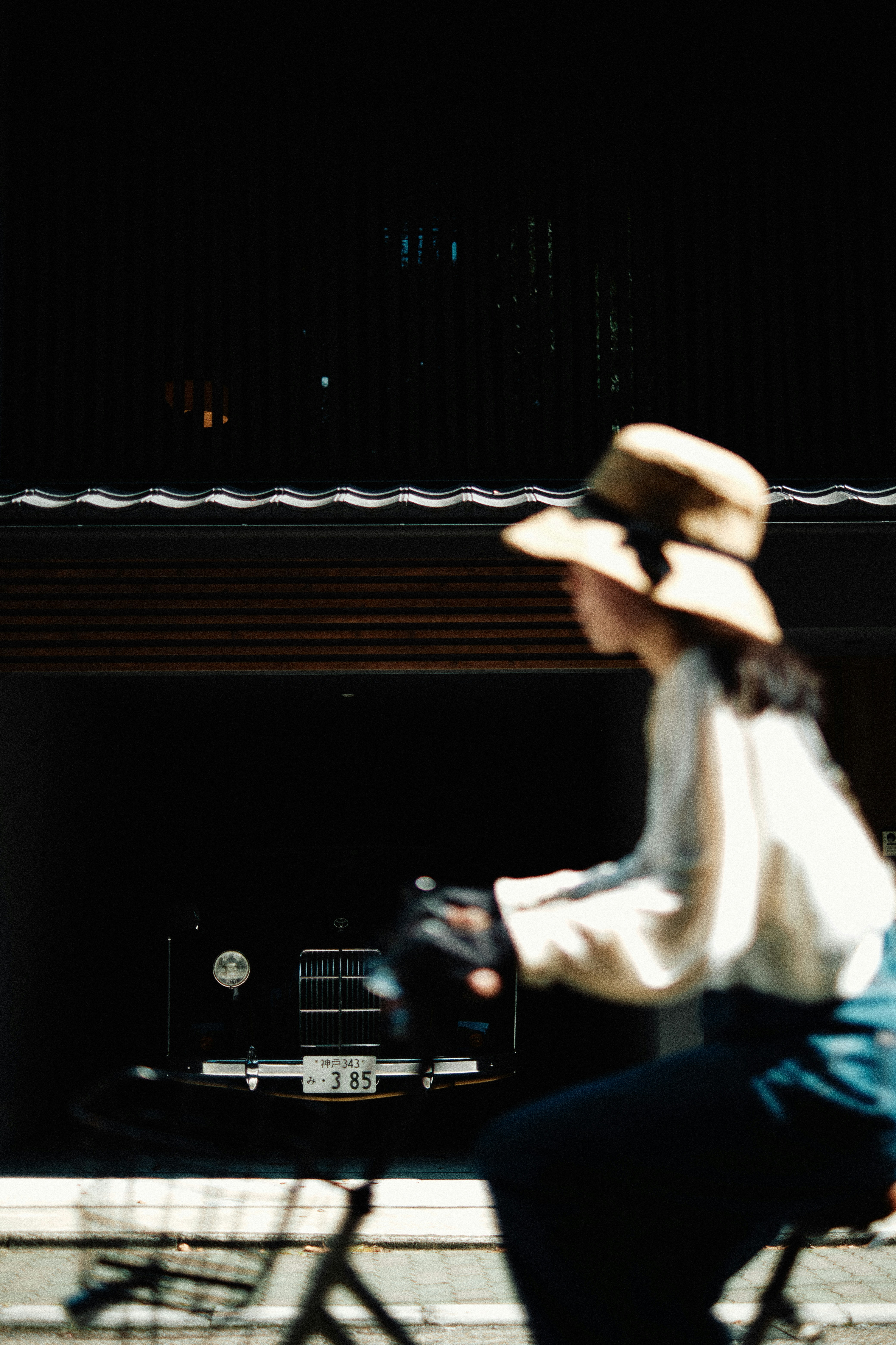 A man riding a bike down a street next to a tall building