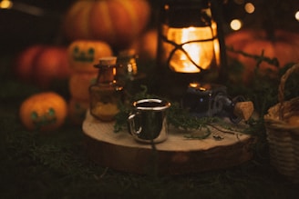 A table topped with lots of pumpkins and a lantern