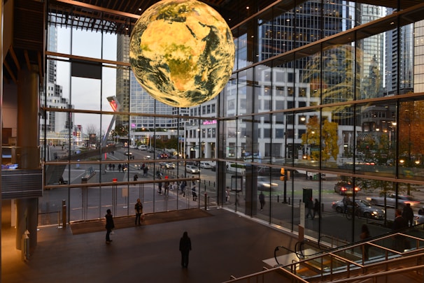 A large glass building with a giant globe hanging from it's ceiling