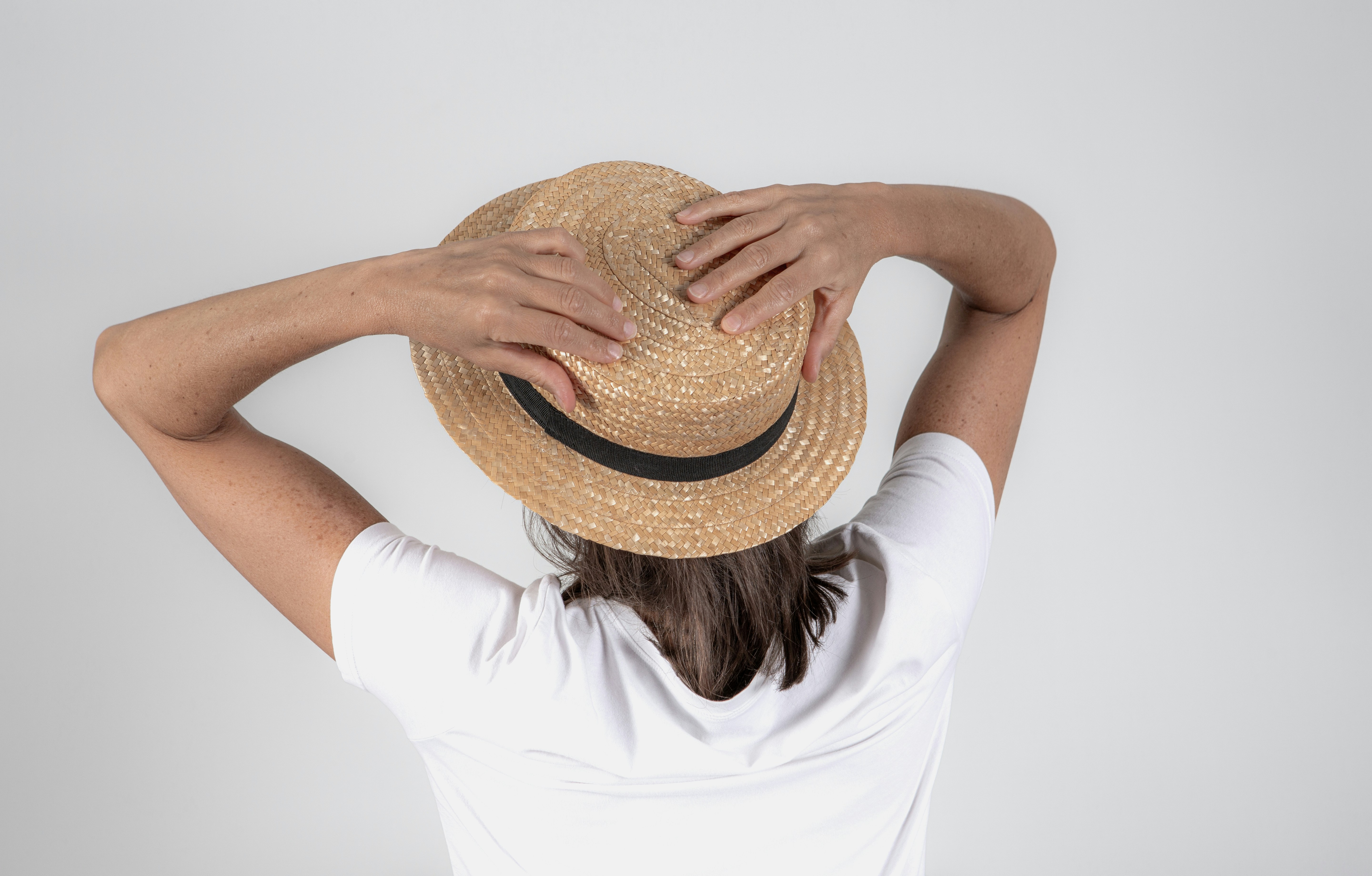 A woman in a white shirt and a straw hat