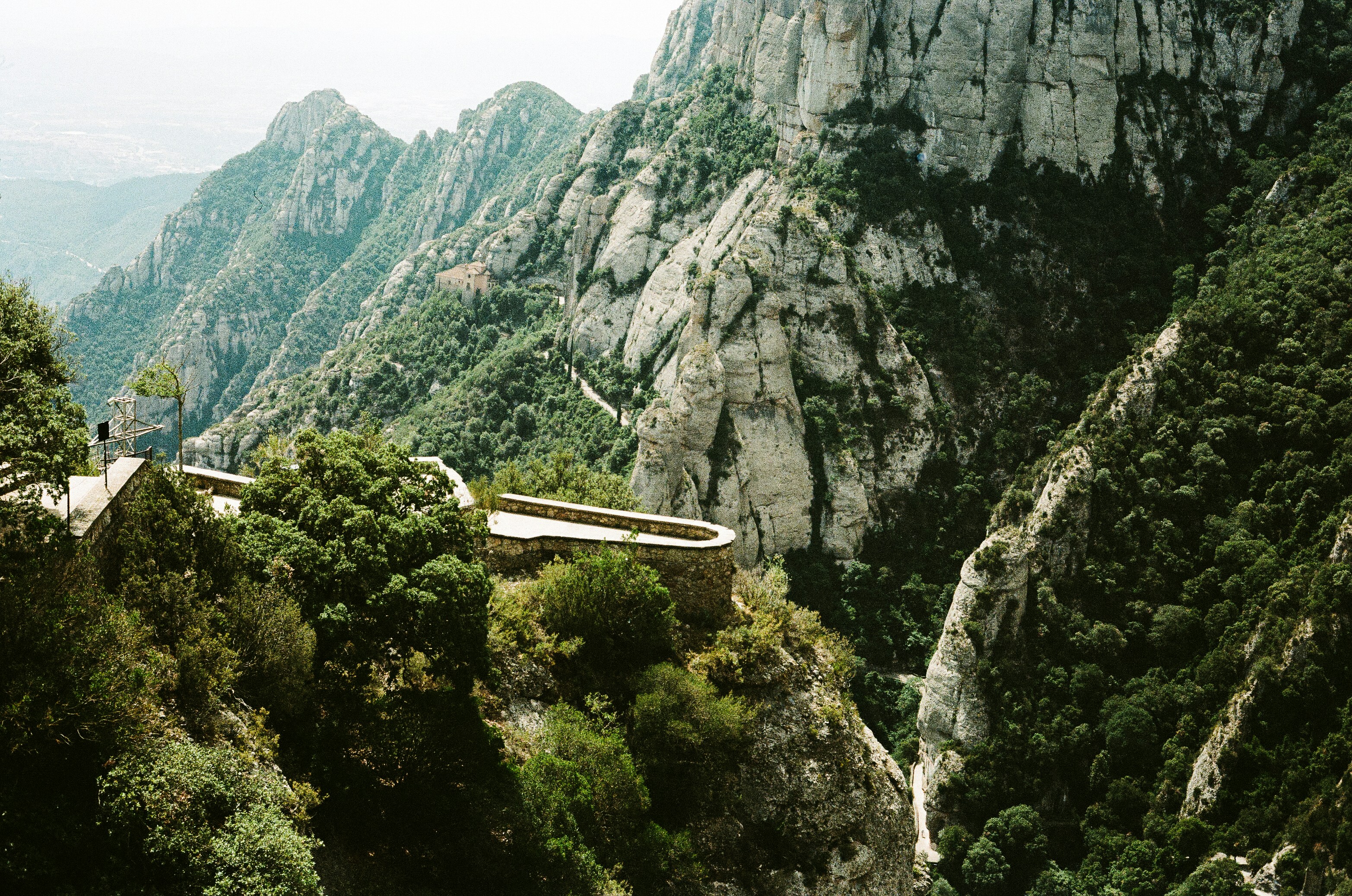 A scenic view of a mountain with a bridge in the middle