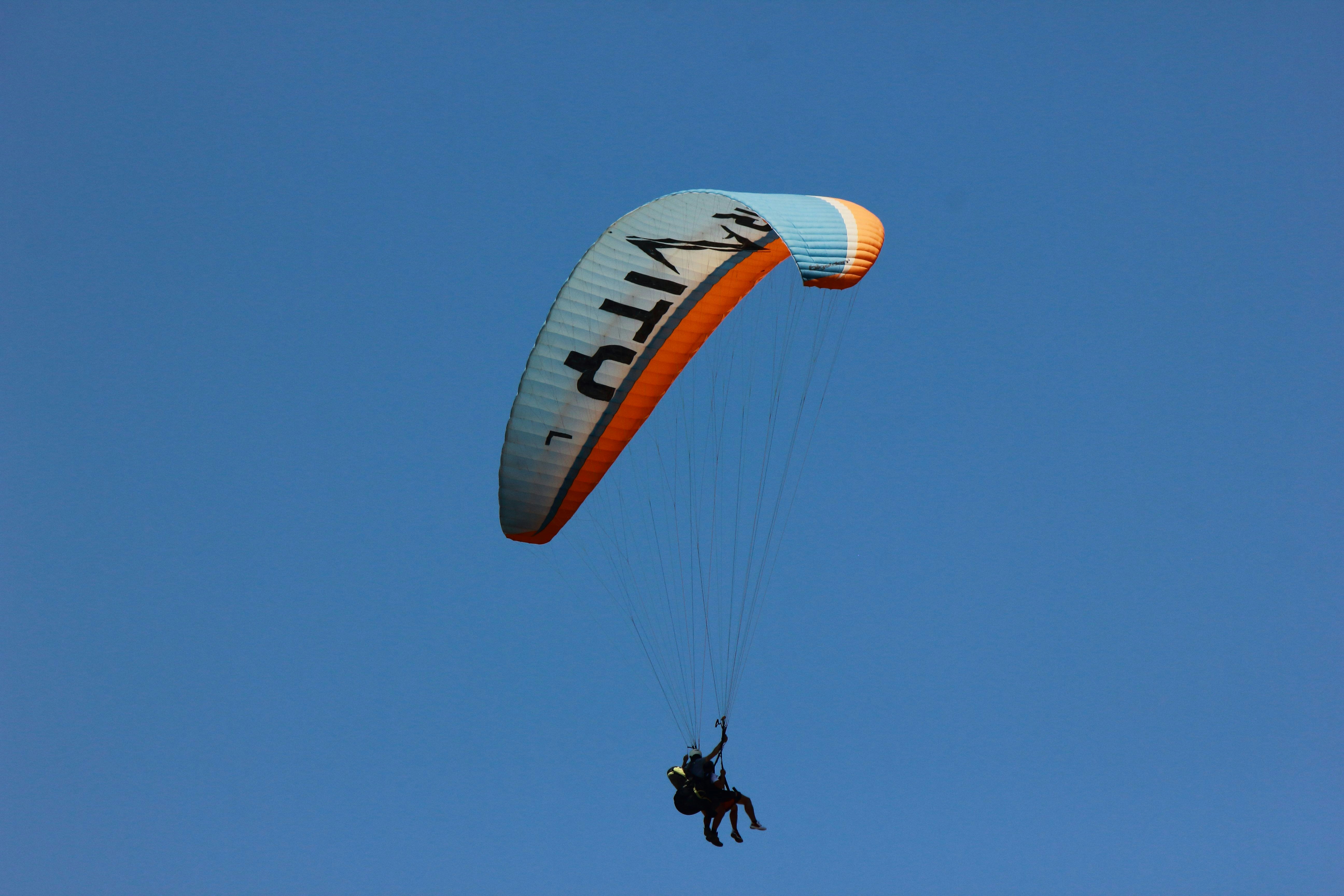 A person is parasailing in the blue sky