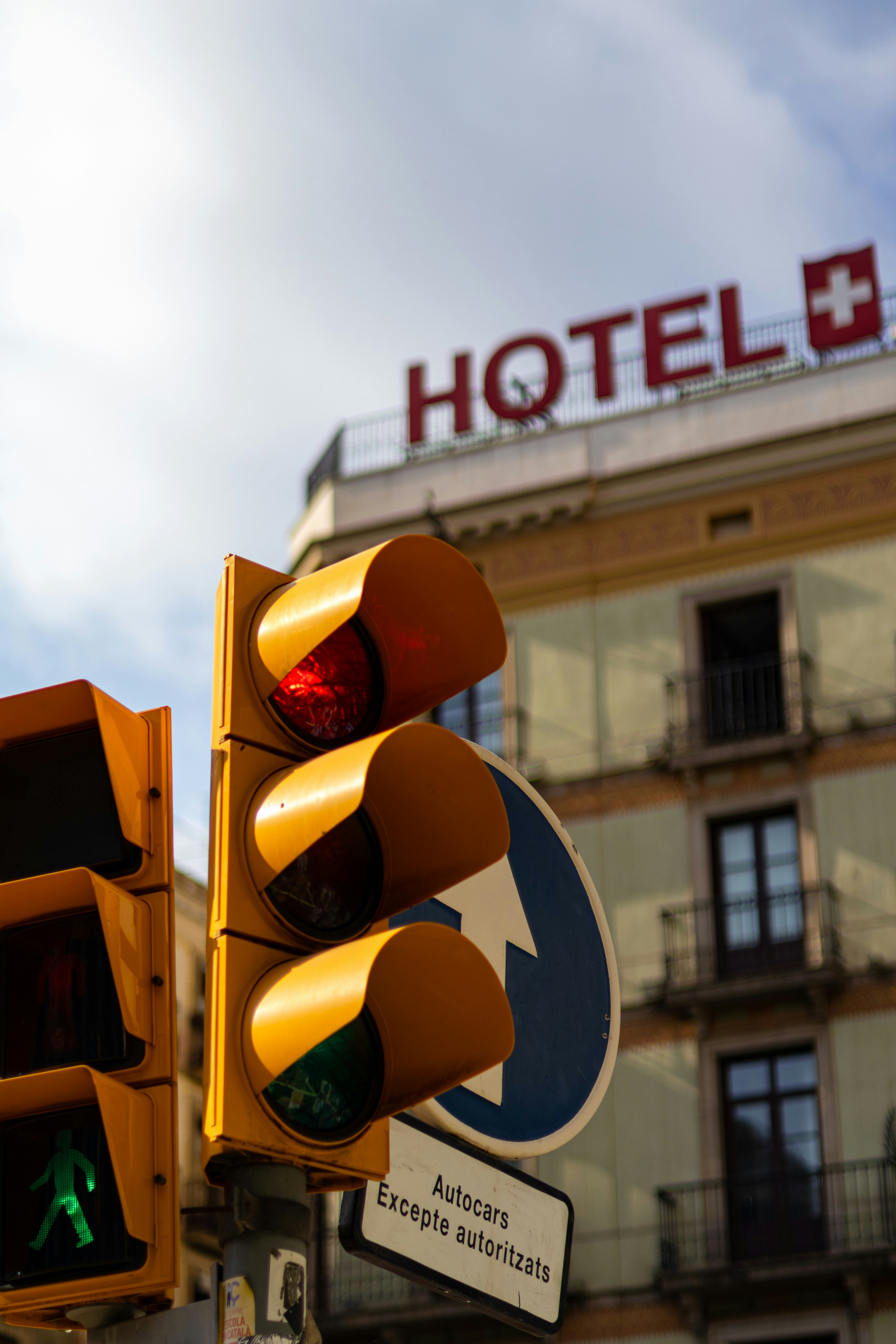 5 Hotel Booking Mistakes That Make Your Stay More Expensive – A traffic light with a hotel sign in the background