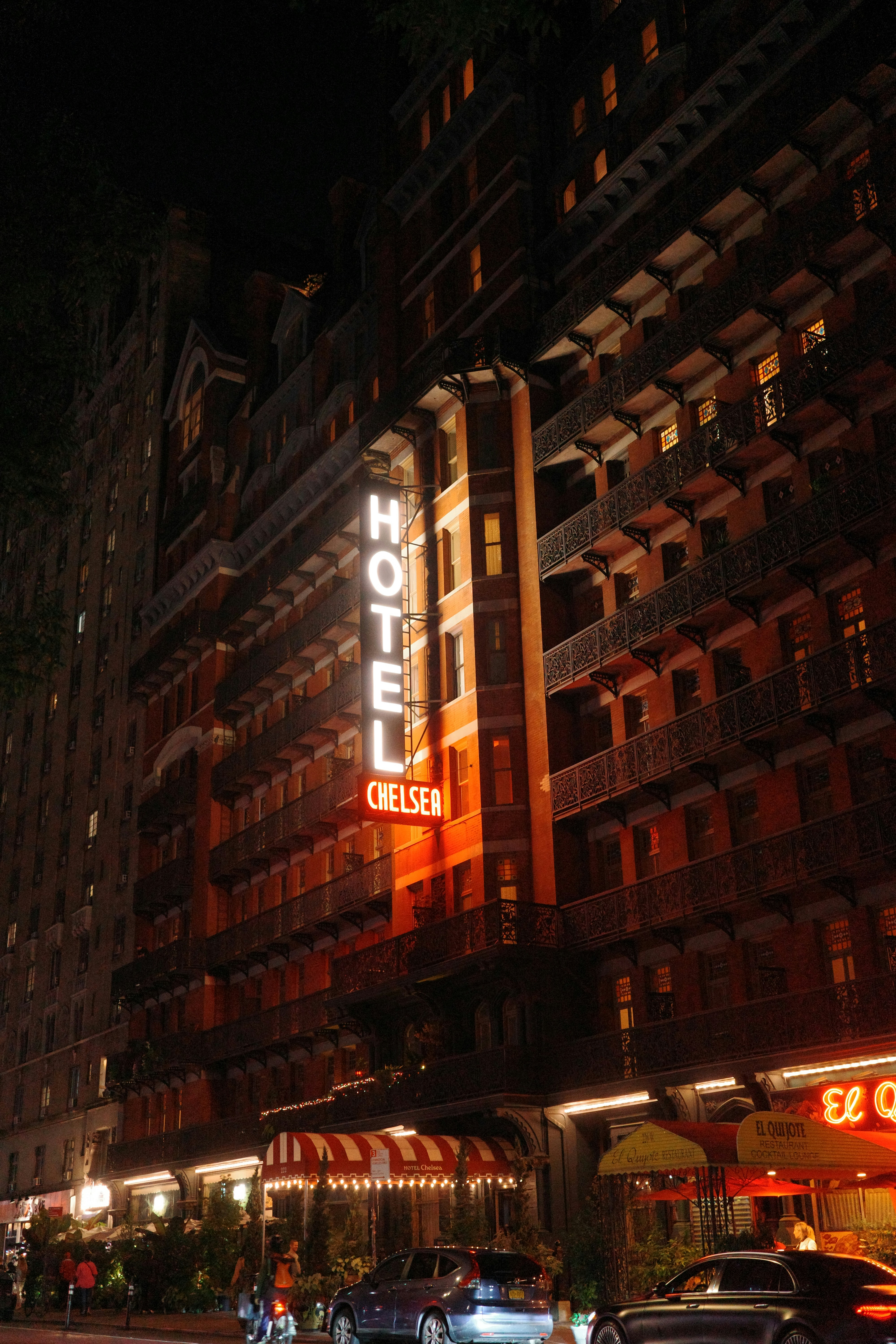 A hotel sign lit up at night on a city street