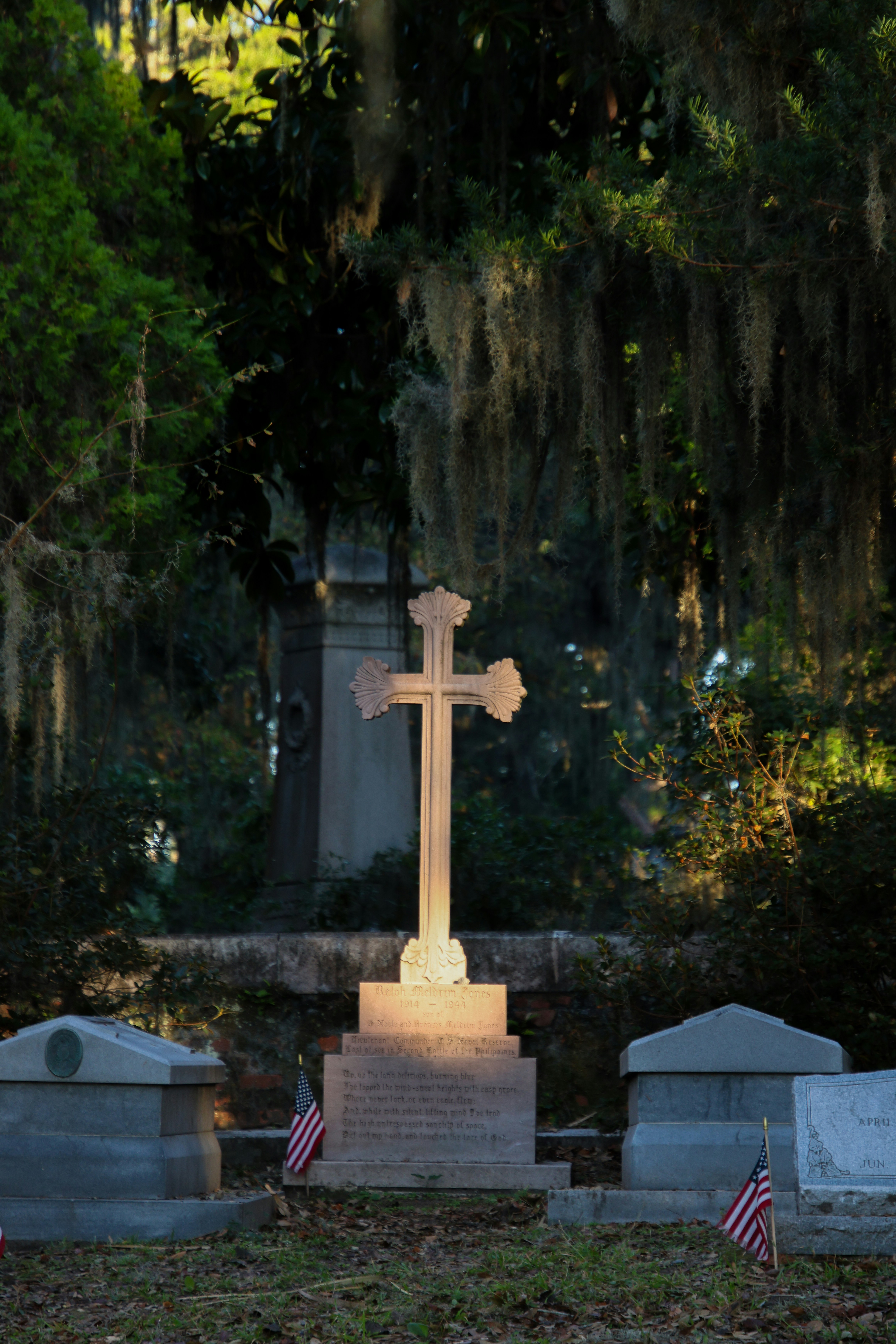 A cemetery with a cross and american flags