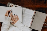 A woman sitting at a table with a notebook and pen