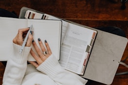 A woman sitting at a table with a notebook and pen
