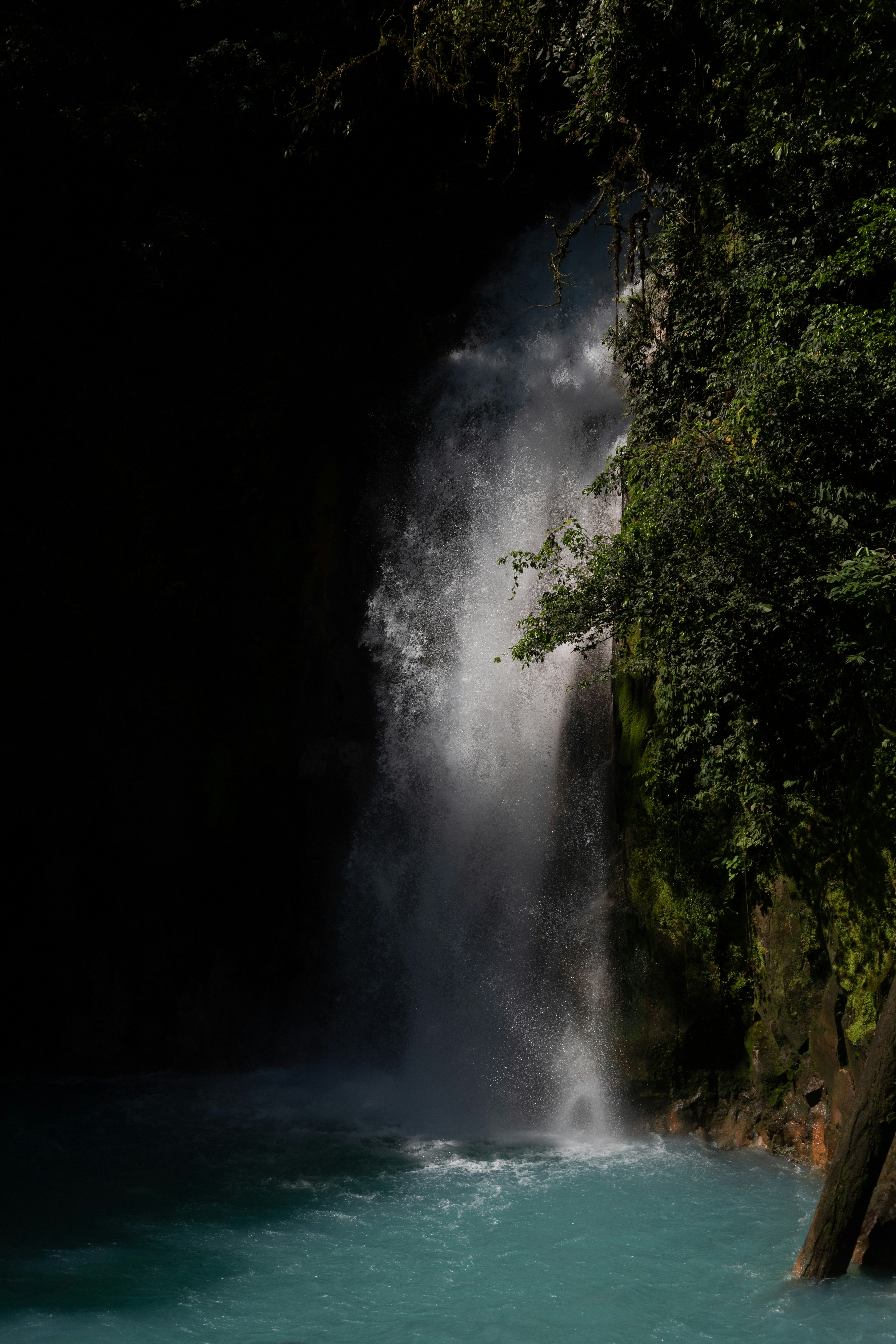 A waterfall with a man standing in front of it