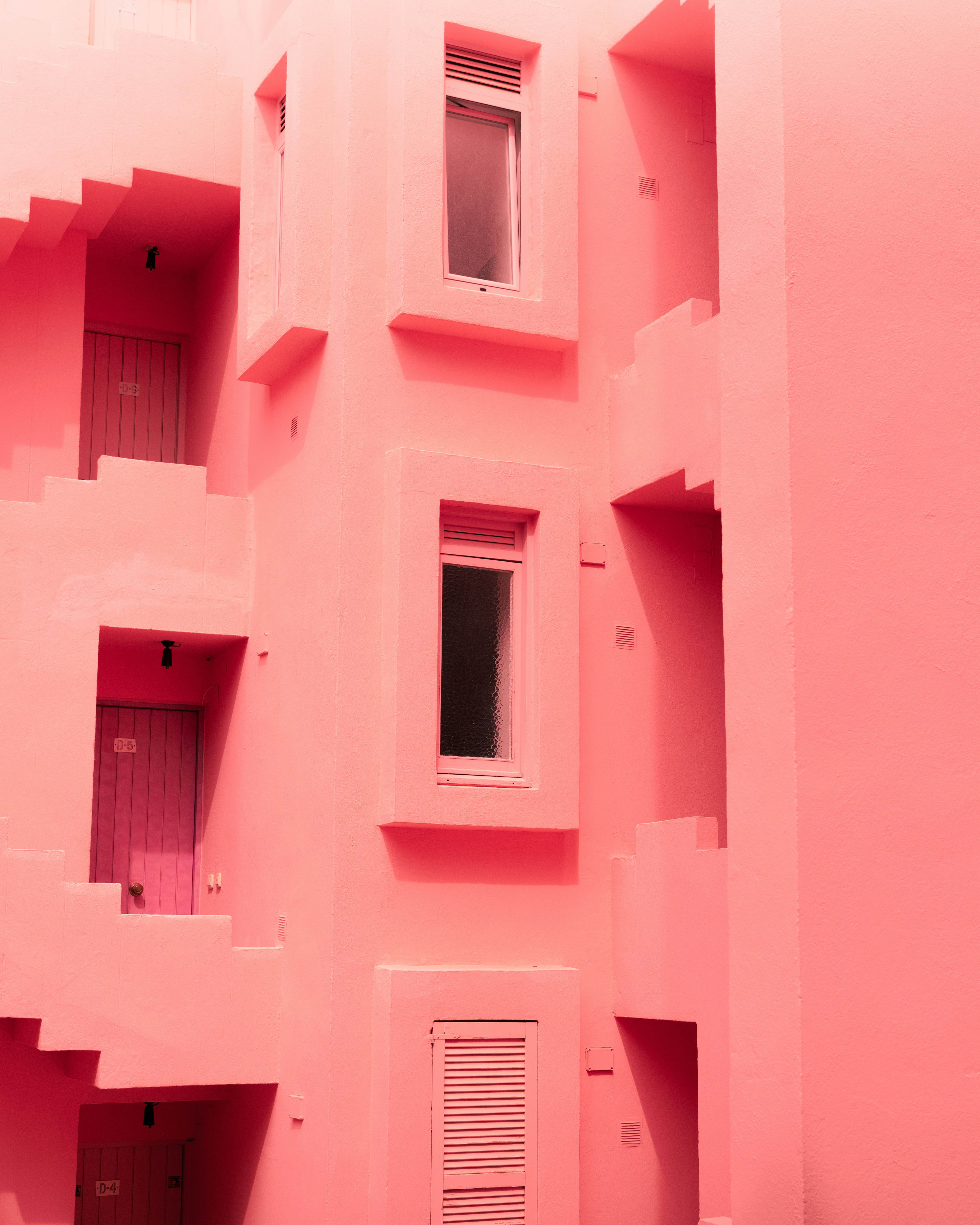 A pink building with multiple balconies and windows photo – Free City ...