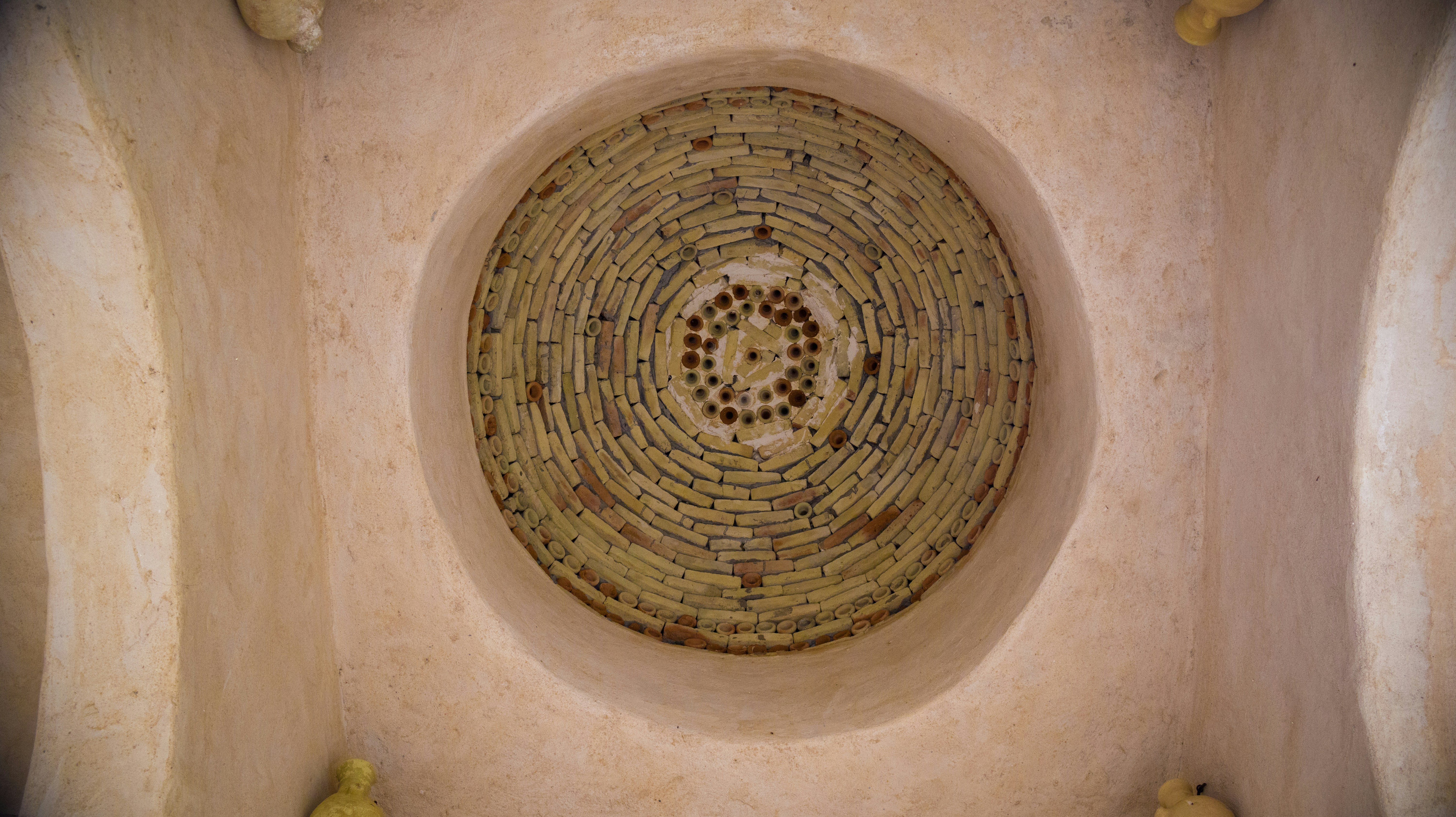 The ceiling of a bathroom has a circular design on it