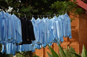 A line of blue shirts hanging on a clothes line