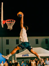 A man jumping in the air to dunk a basketball