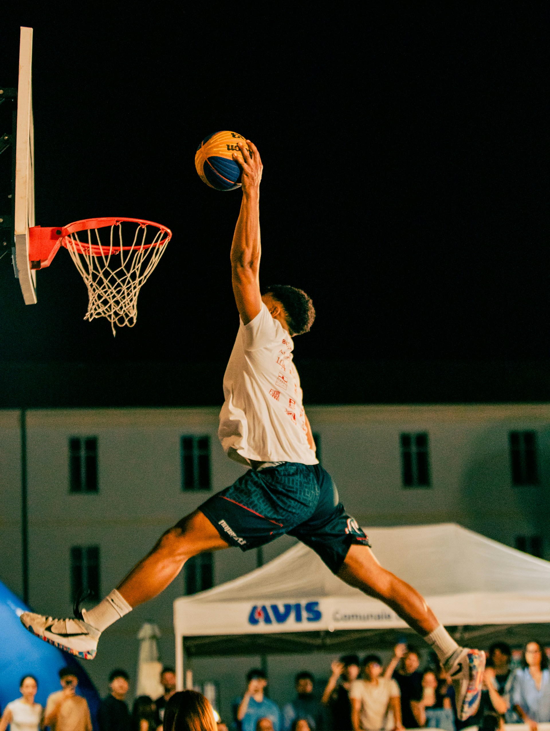A man jumping in the air to dunk a basketball