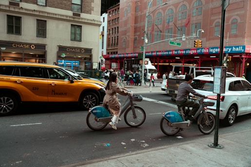 A couple of people riding bikes down a street