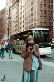 A man standing on the side of a street while talking on a cell phone
