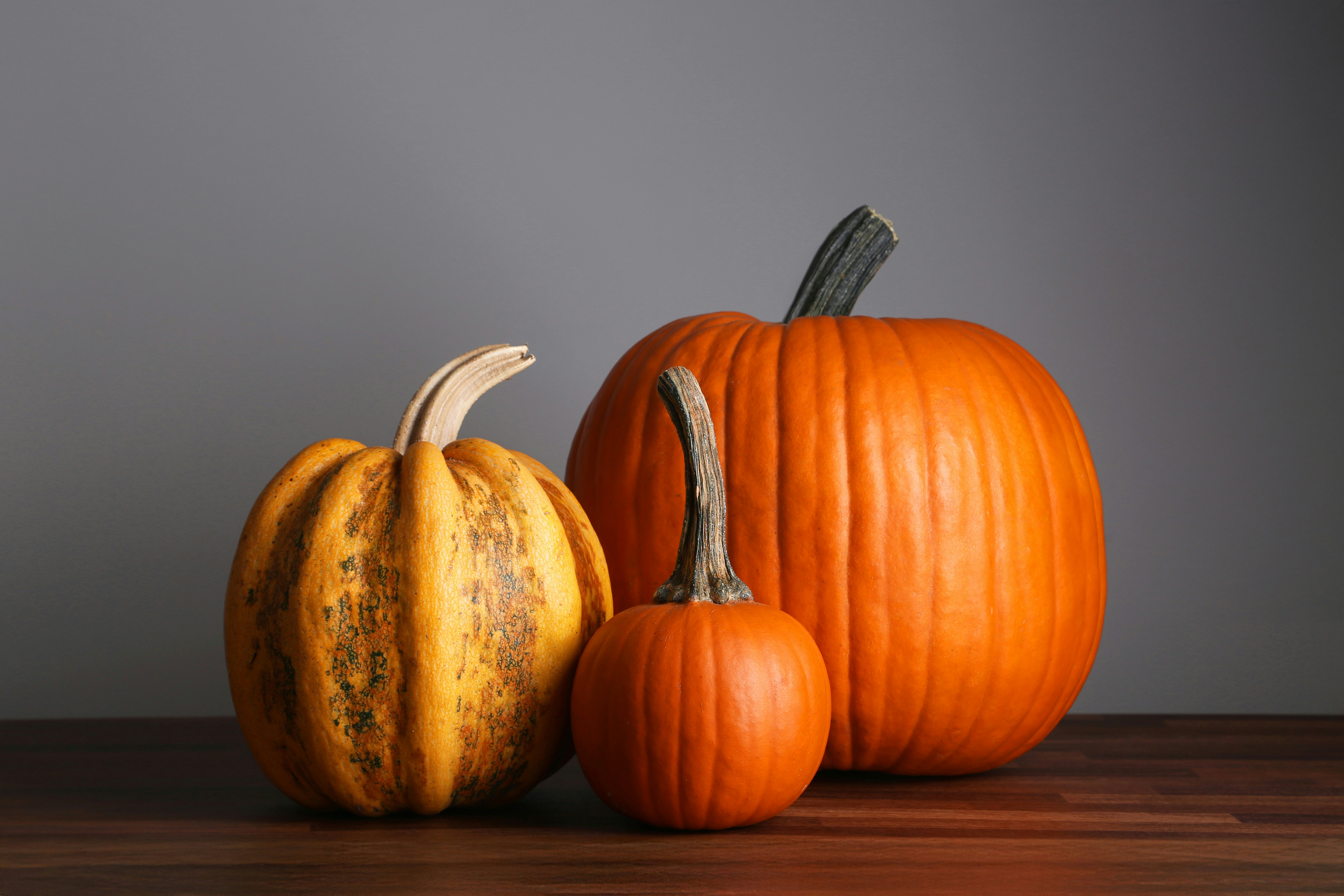 A couple of pumpkins sitting on top of a wooden table