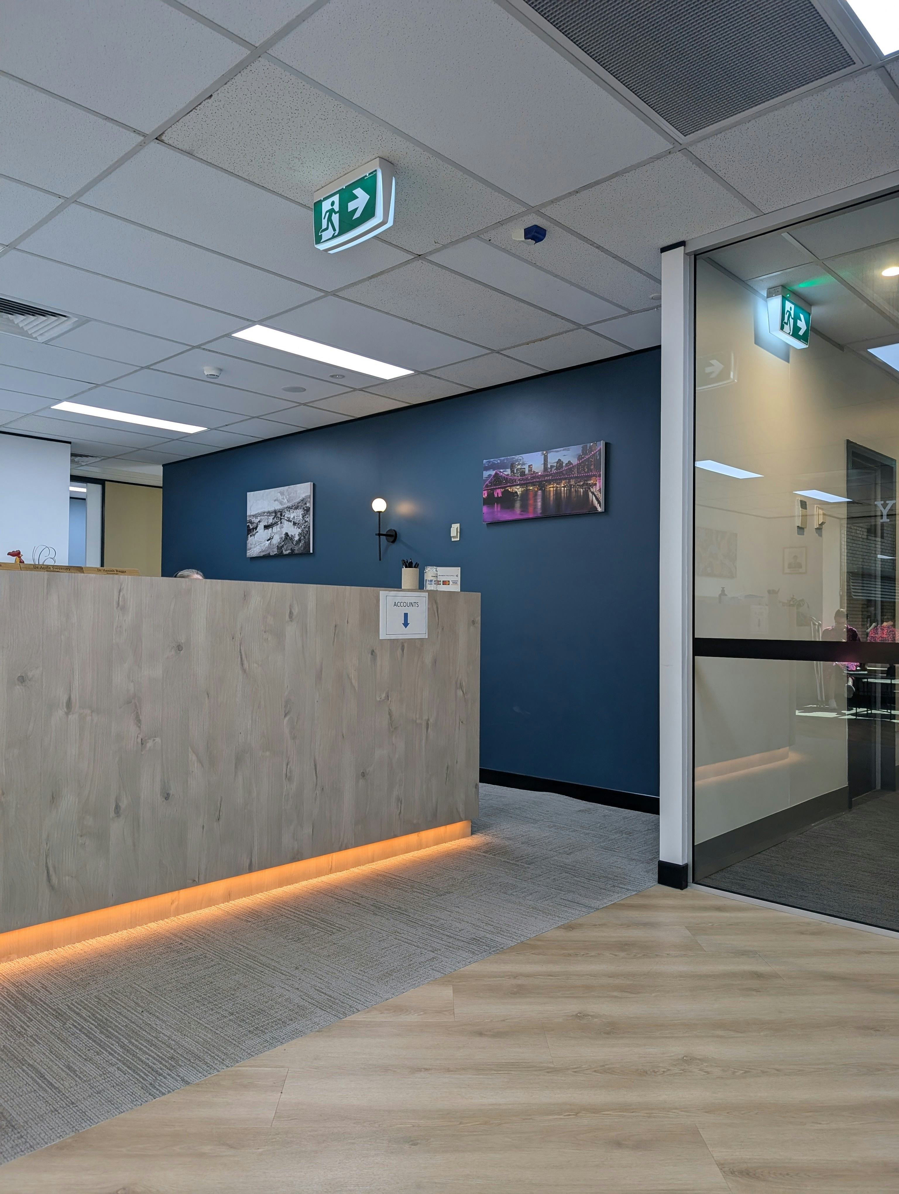 Modern office reception desk in dim blue lighting, dark walls, atmospheric business environment