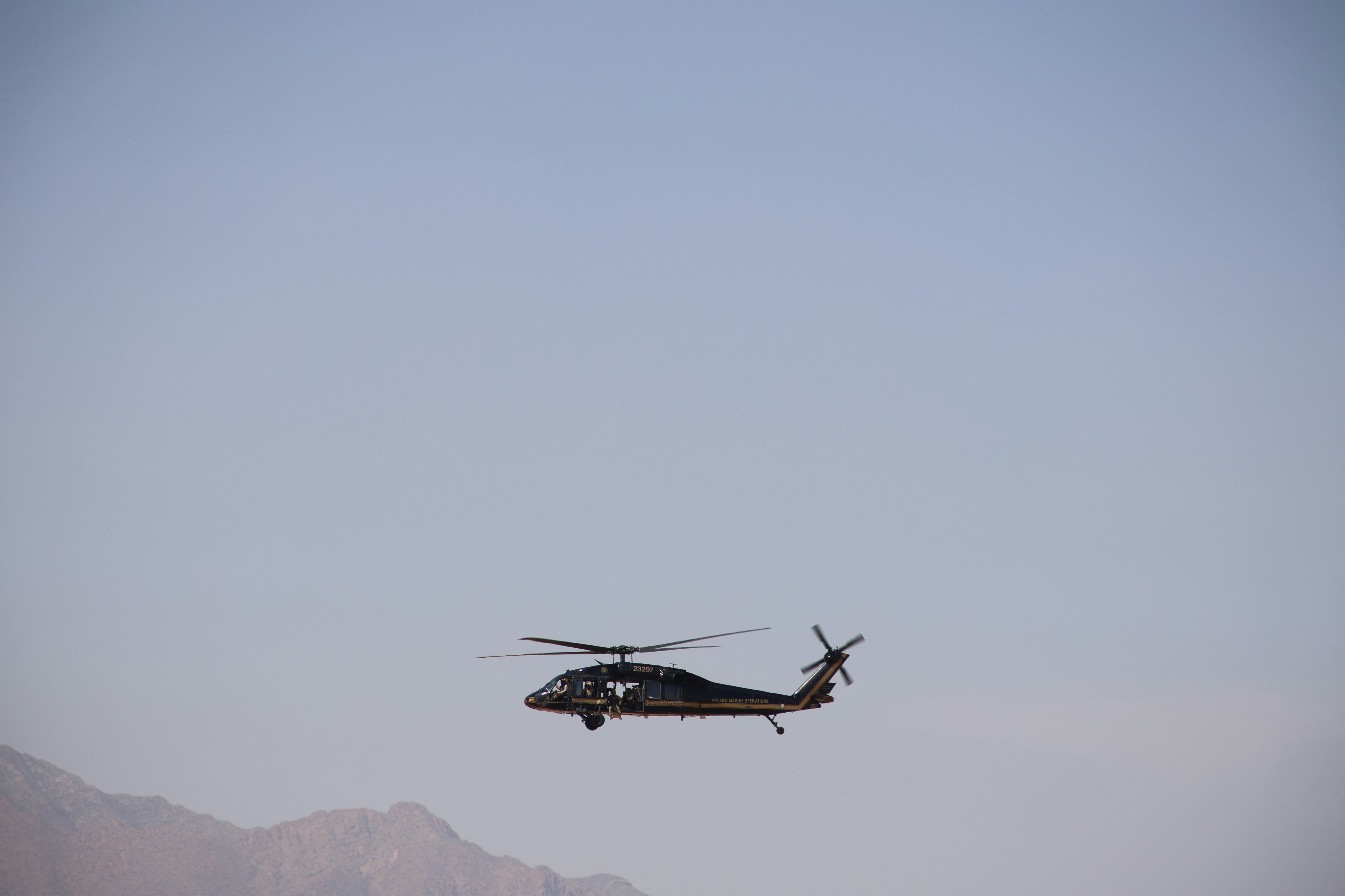 Ein Hubschrauber, der am Himmel fliegt, mit Bergen im Hintergrund