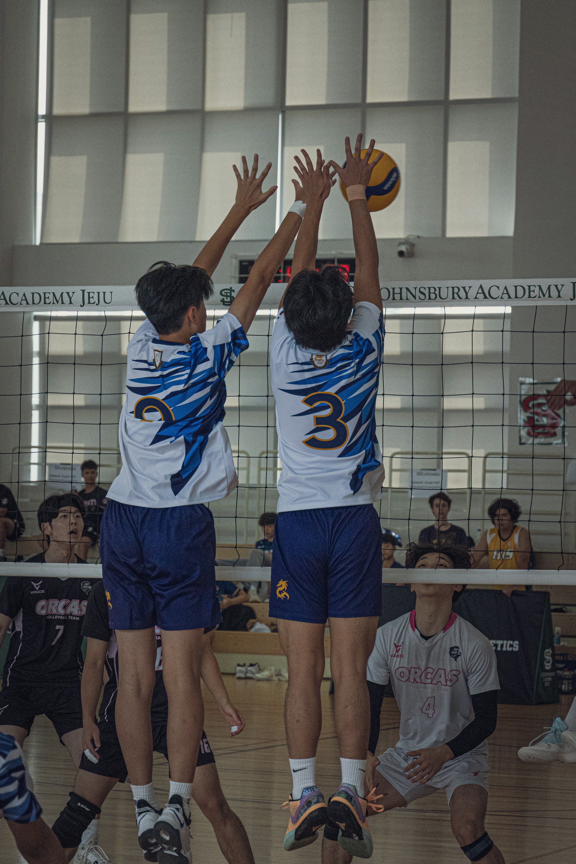 A group of young men playing a game of volleyball