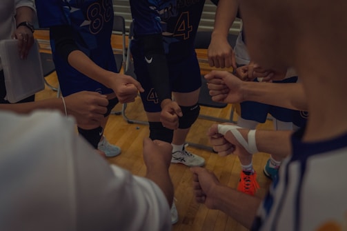 A group of men standing around each other on a basketball court