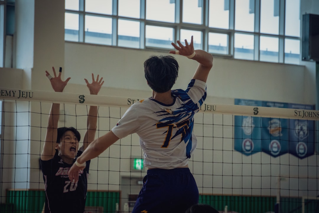 A group of young men playing a game of volleyball,
