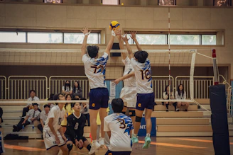 A group of young men playing a game of volleyball