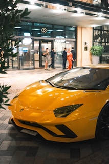 A yellow sports car parked in front of a building