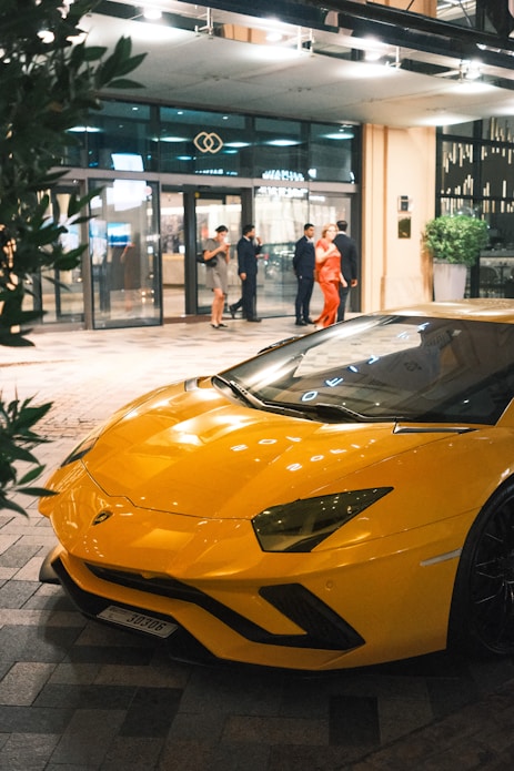 A yellow sports car parked in front of a building