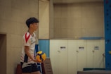 A boy holding a soccer ball in a gym