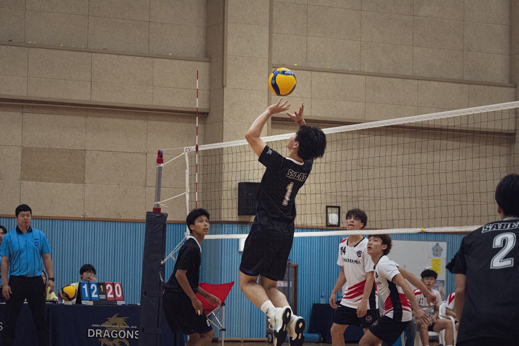 College students playing volleyball in an indoor gym, representing Baylor intramural sports and campus recreation