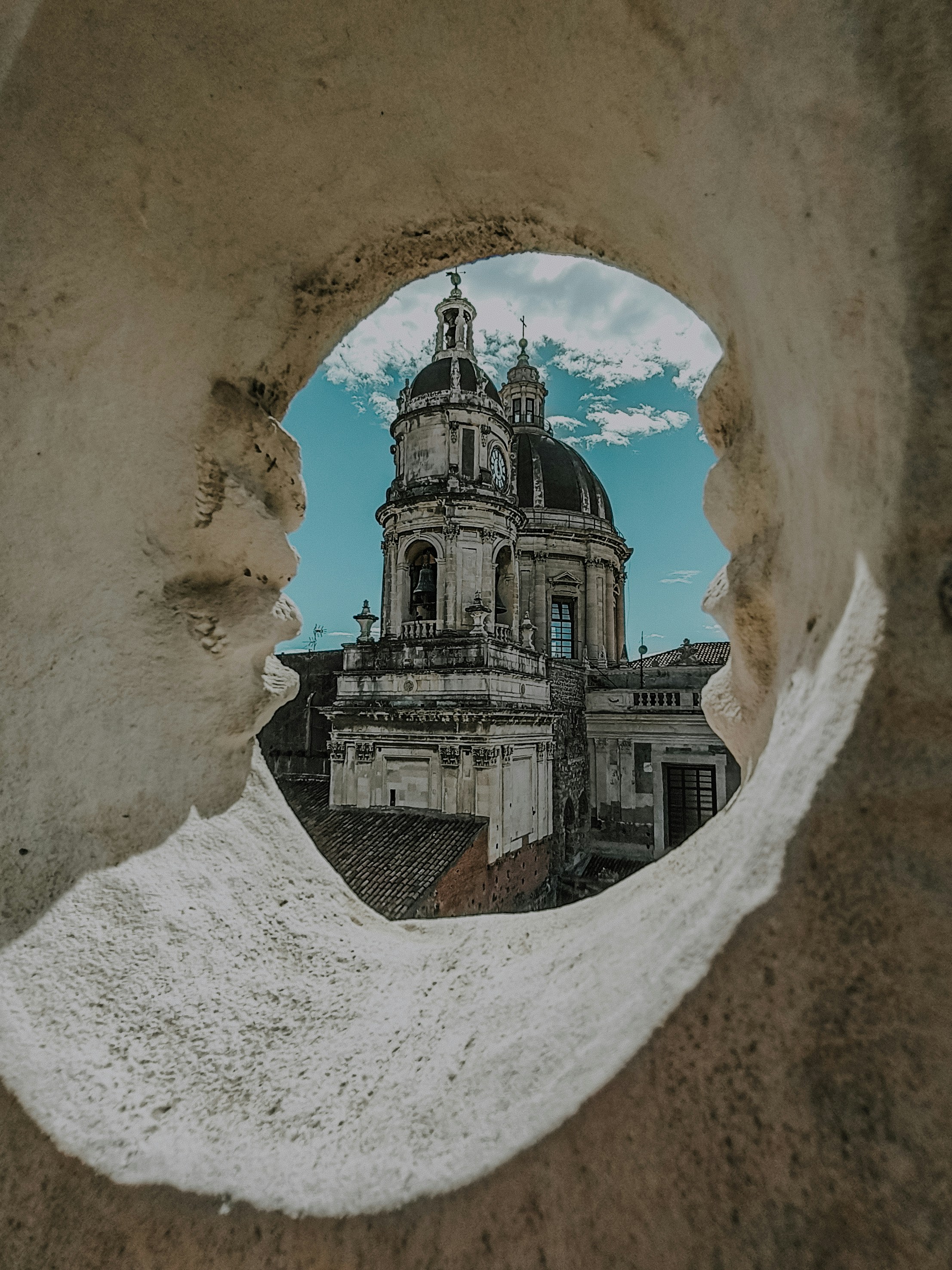 A view of a building through a hole in a wall