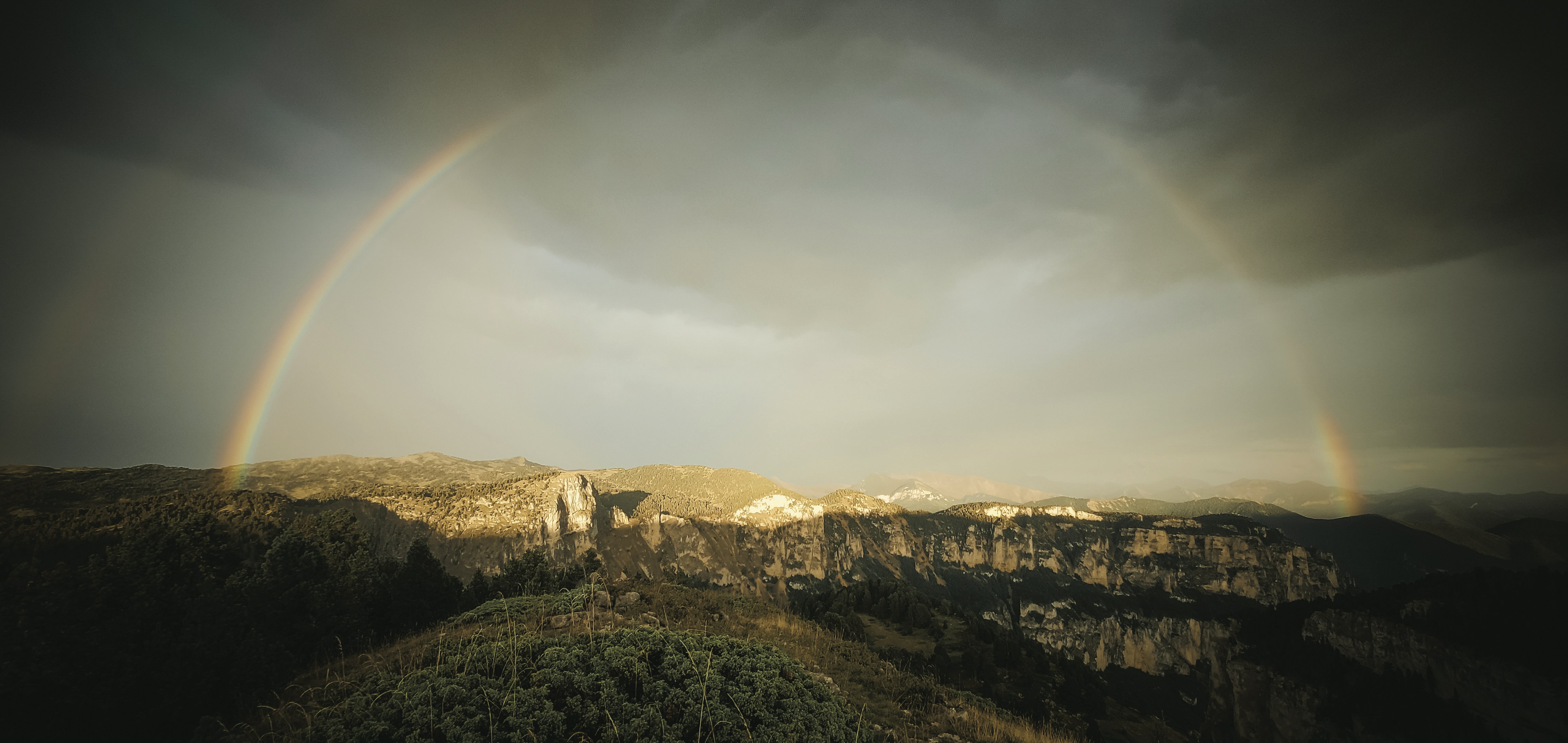 A double rainbow is seen over a city