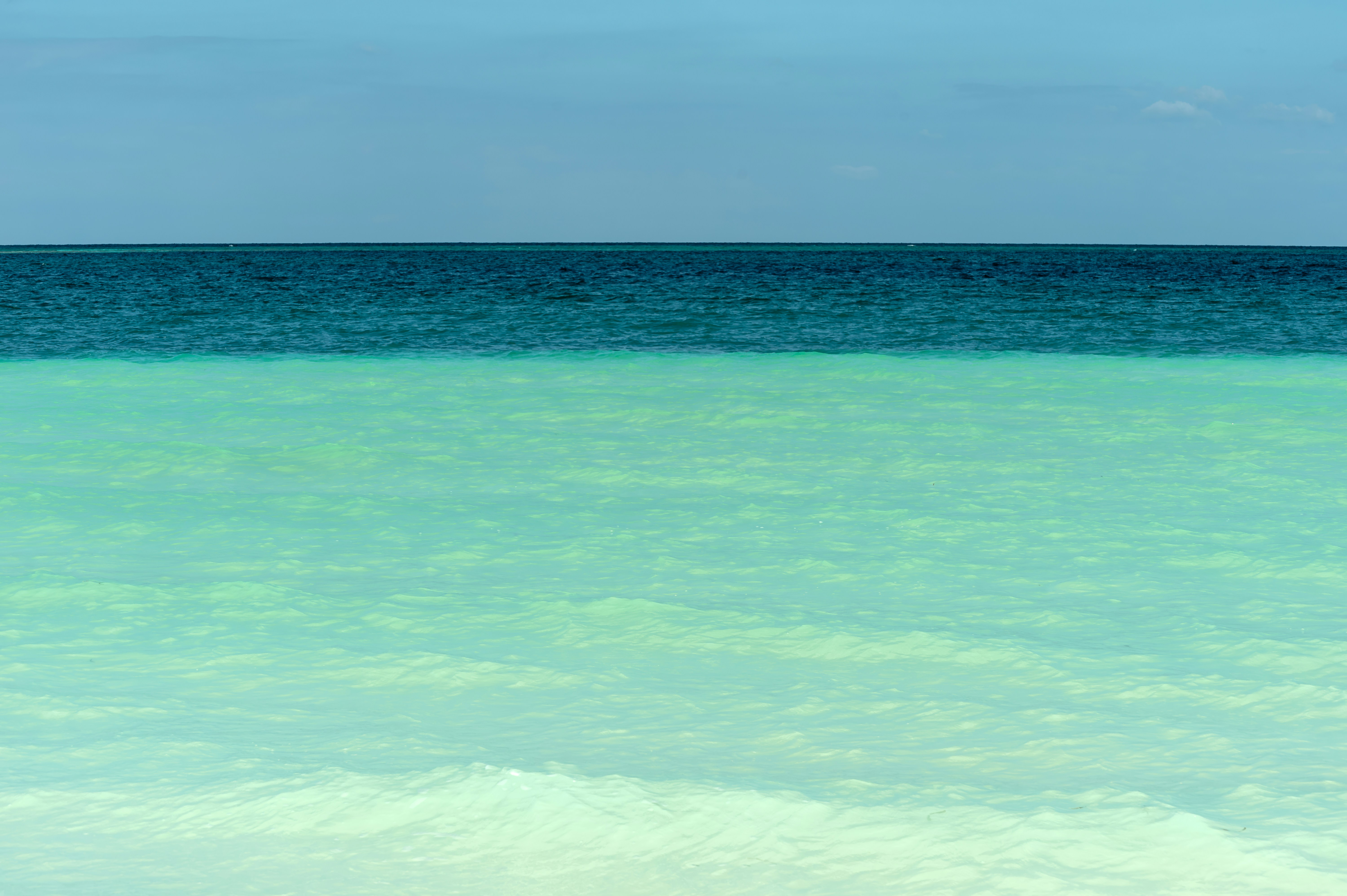 A person standing in the ocean with a surfboard
