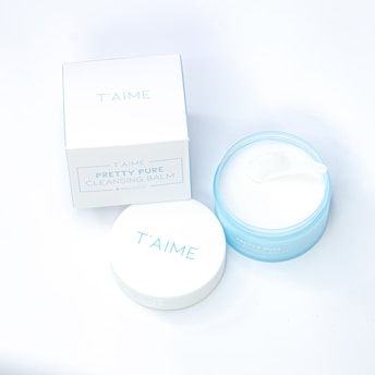 A white container with a blue lid next to a white box