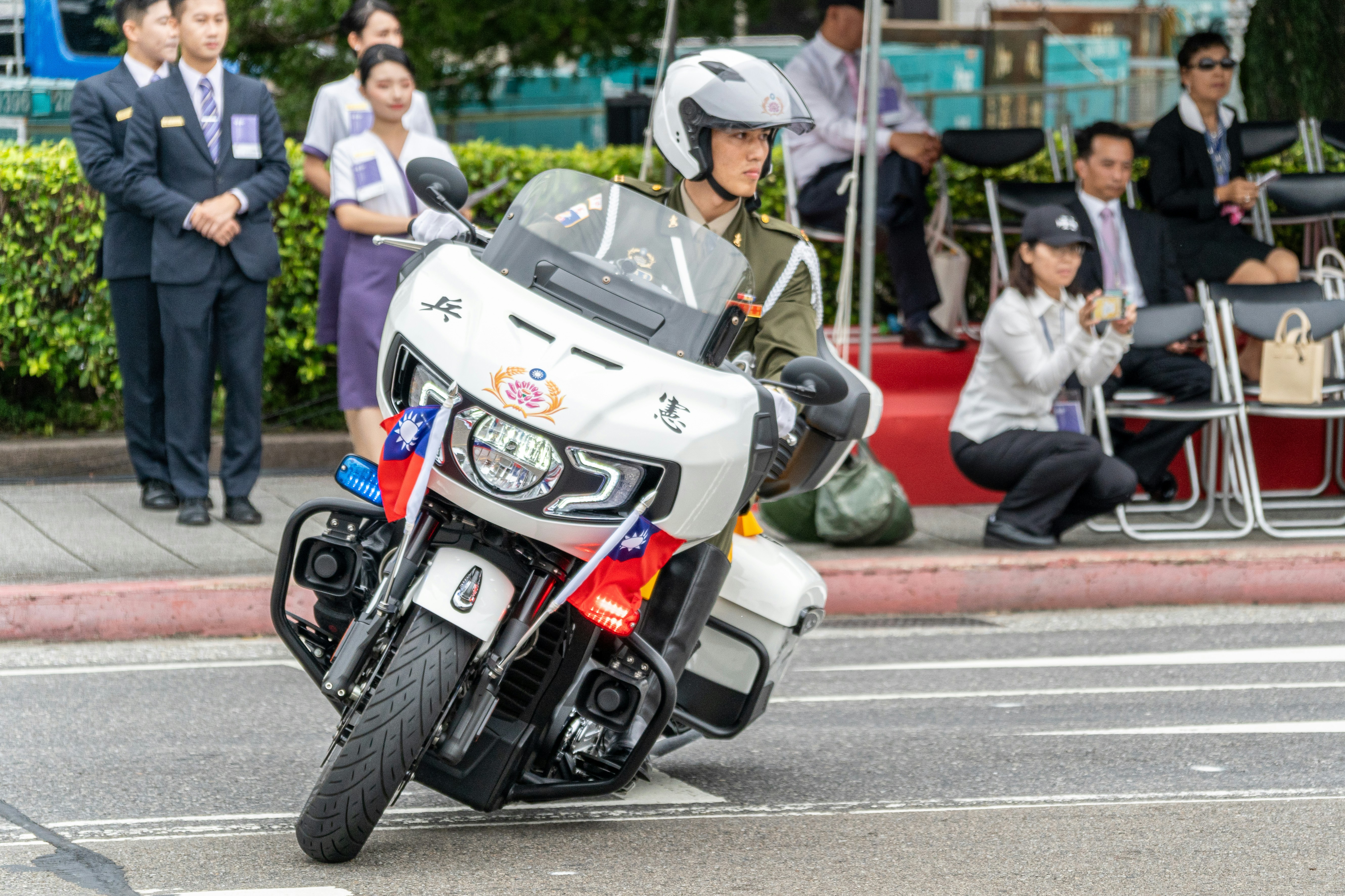 A police officer riding a motorcycle down a street photo – Free Green ...