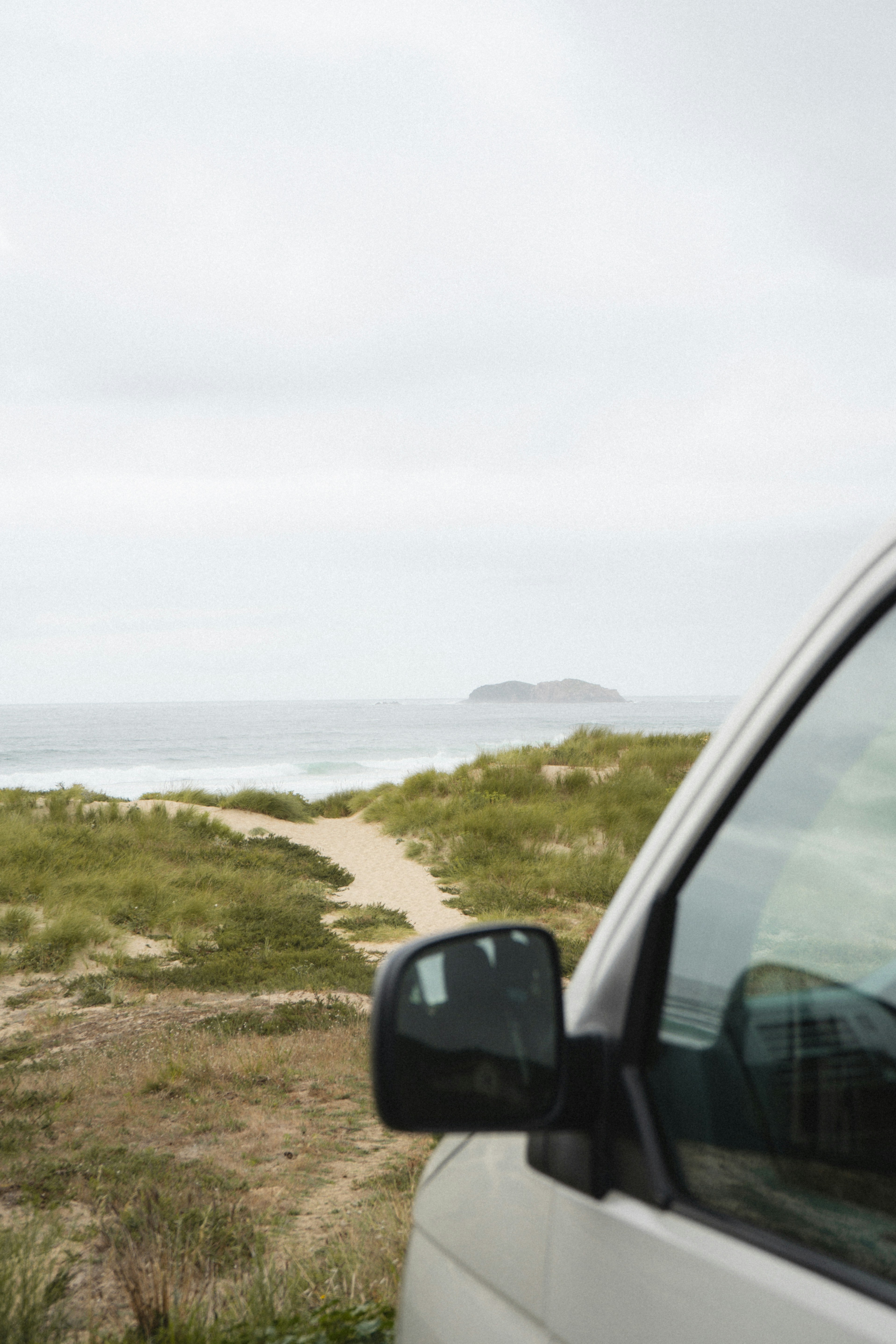 A van parked on the side of the road near a beach