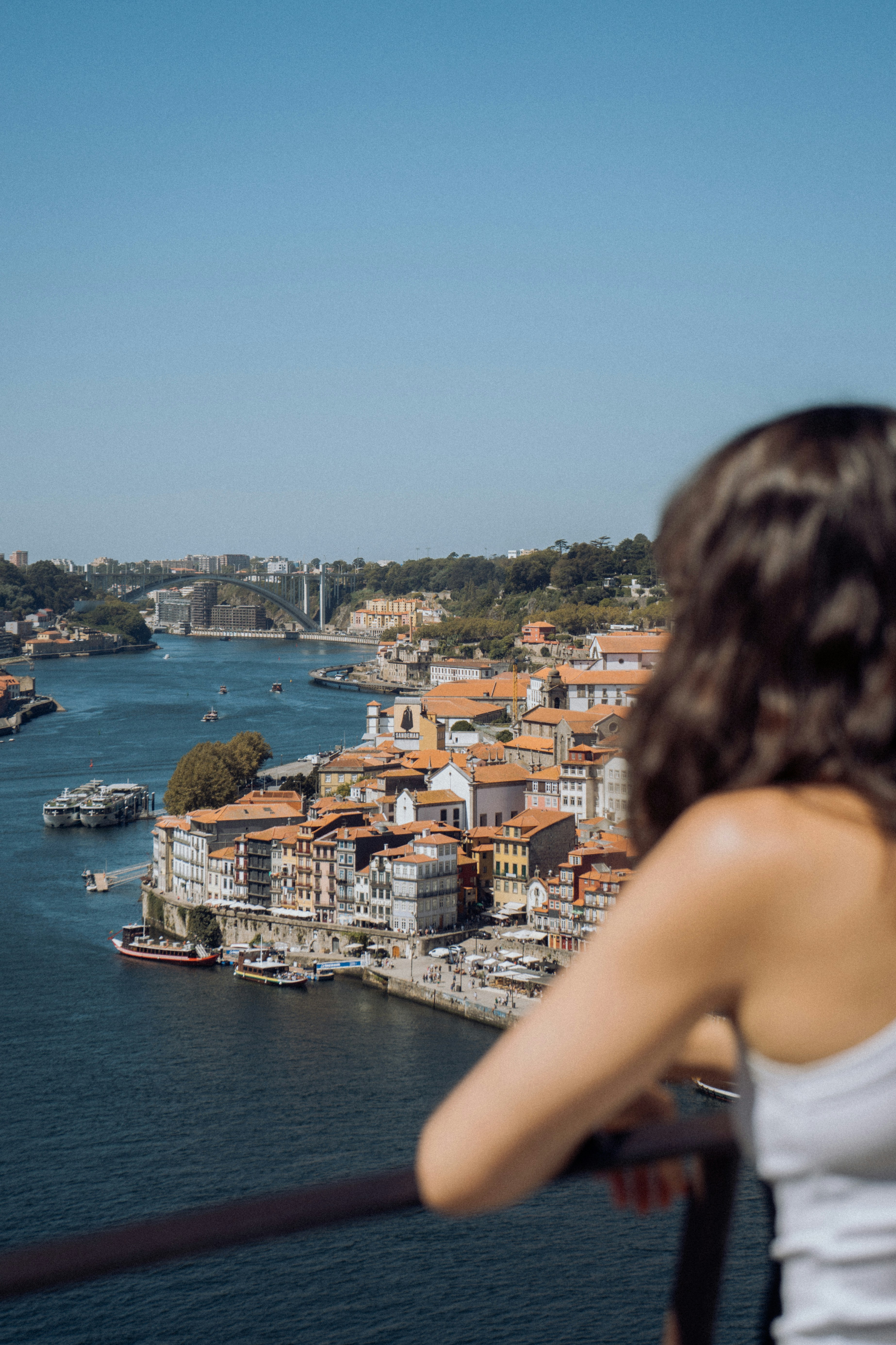 A woman standing on a balcony overlooking a city