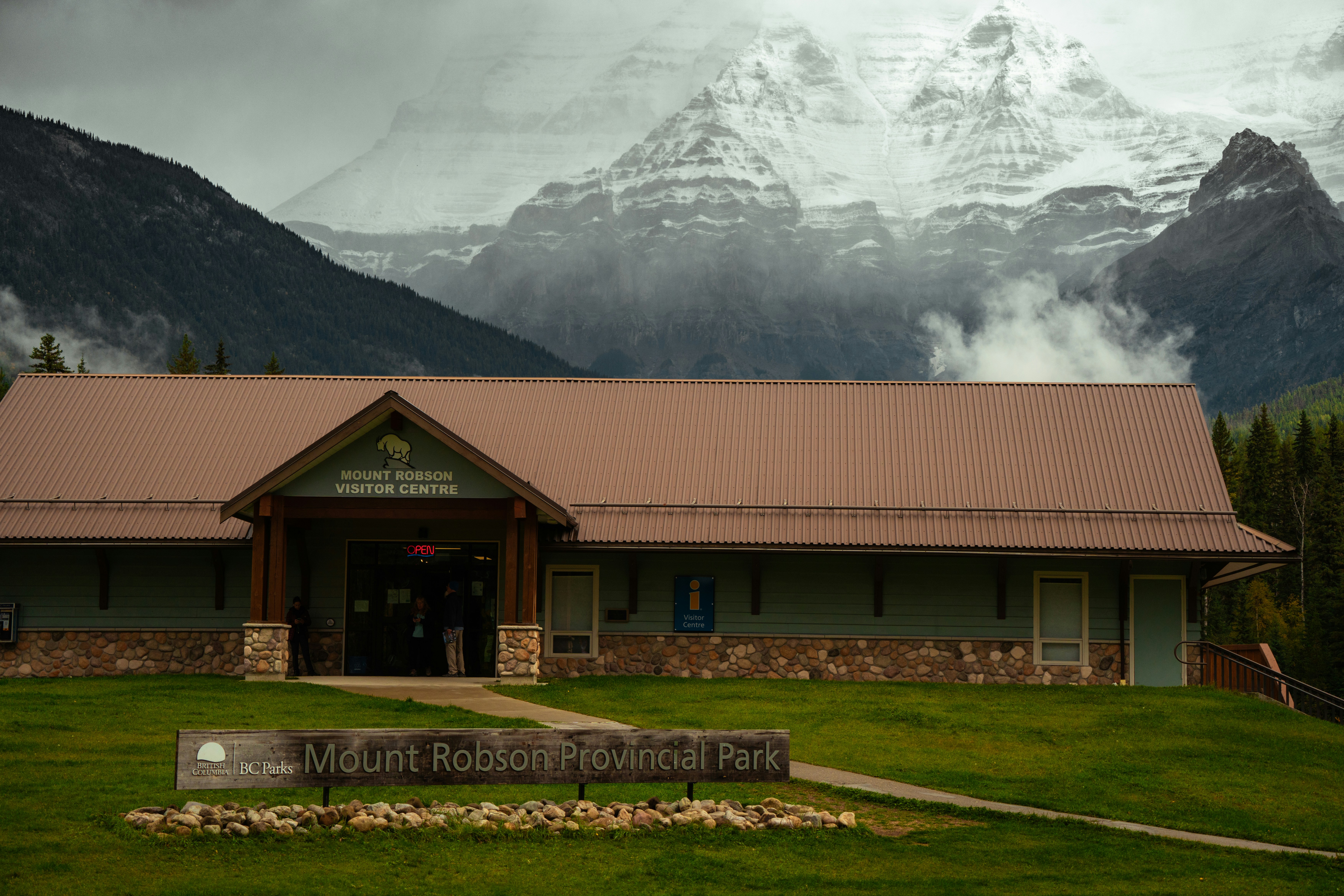 A building with a sign in front of a mountain range
