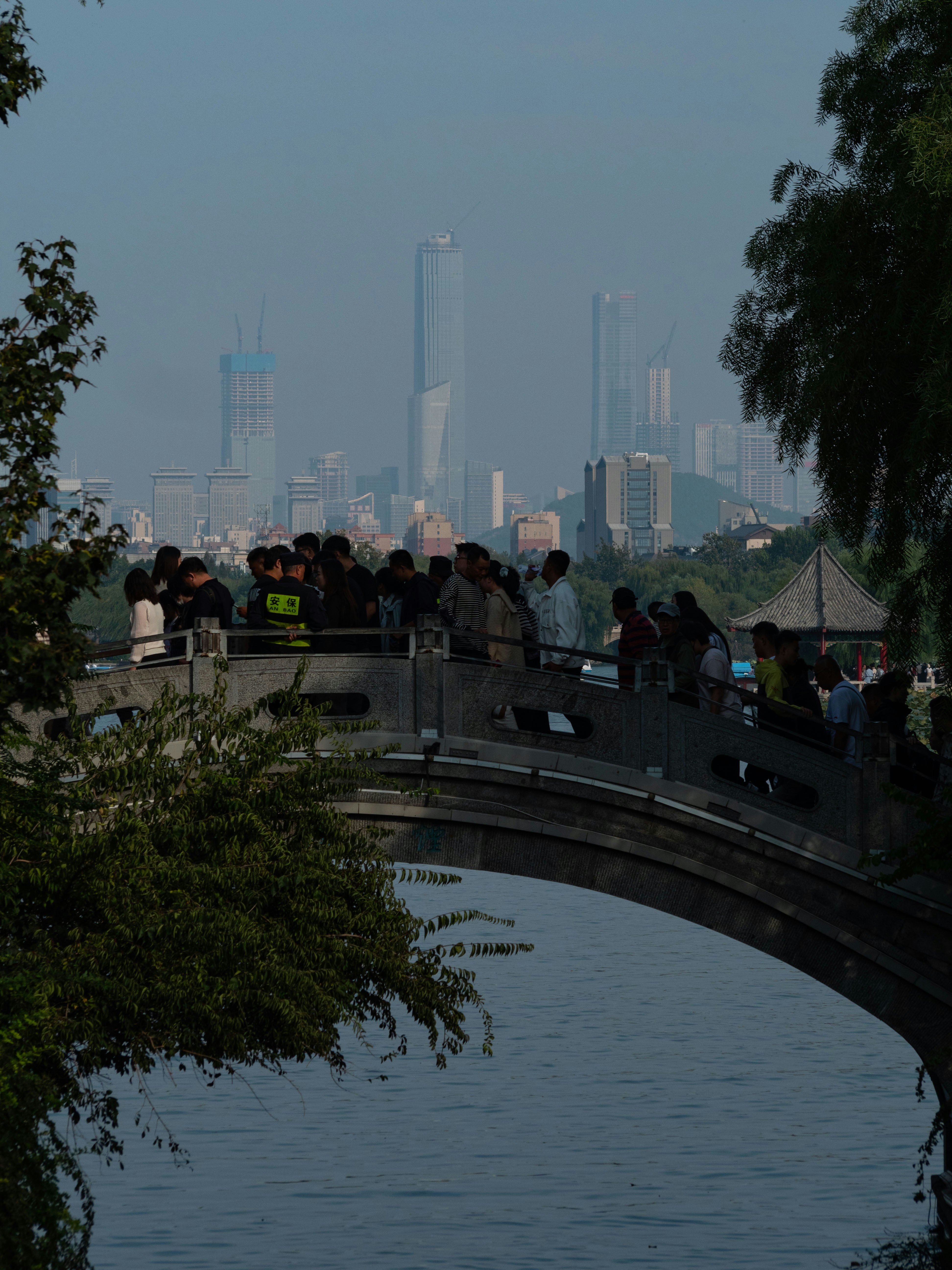 A group of people standing on a bridge over a body of water