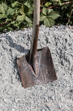 A shovel sitting on top of a pile of gravel