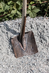 A shovel sitting on top of a pile of gravel