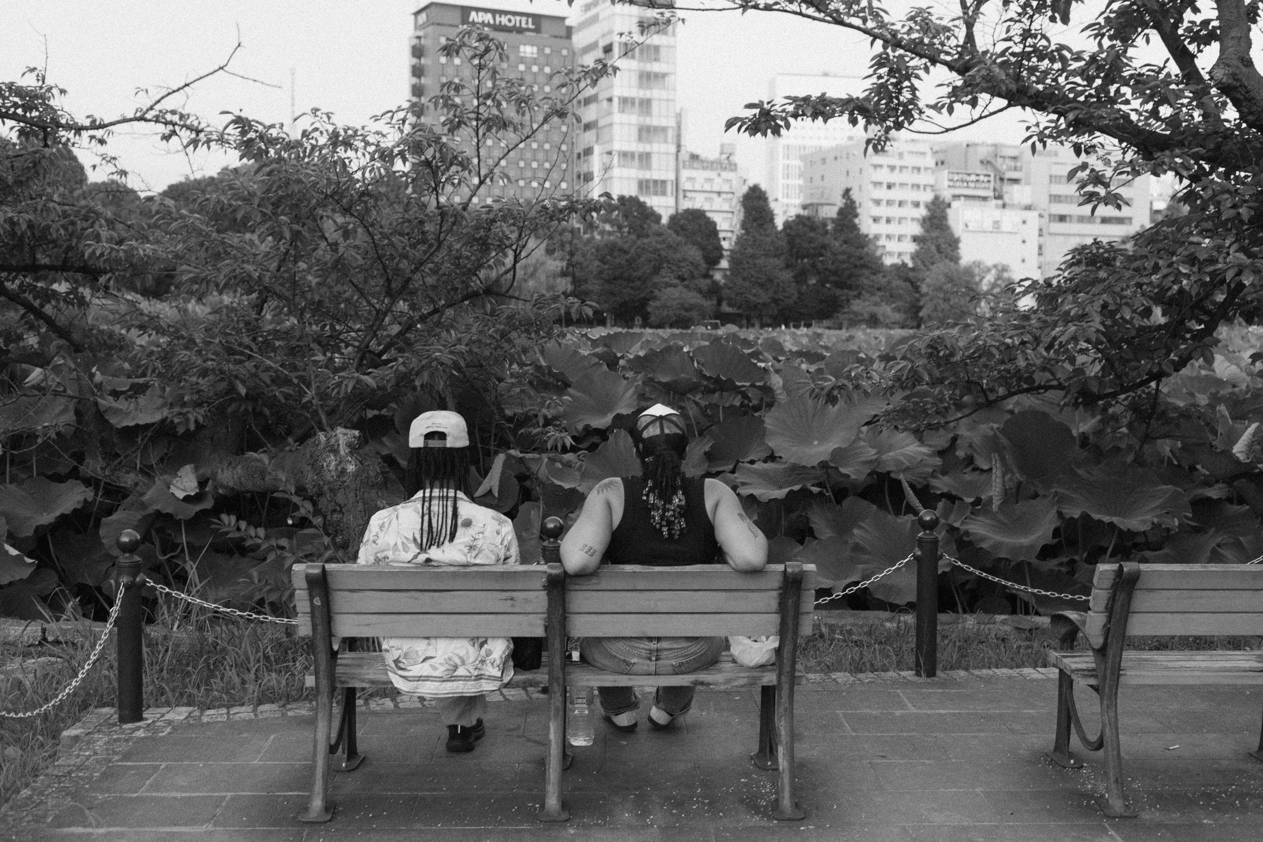 A couple of people sitting on top of a wooden bench