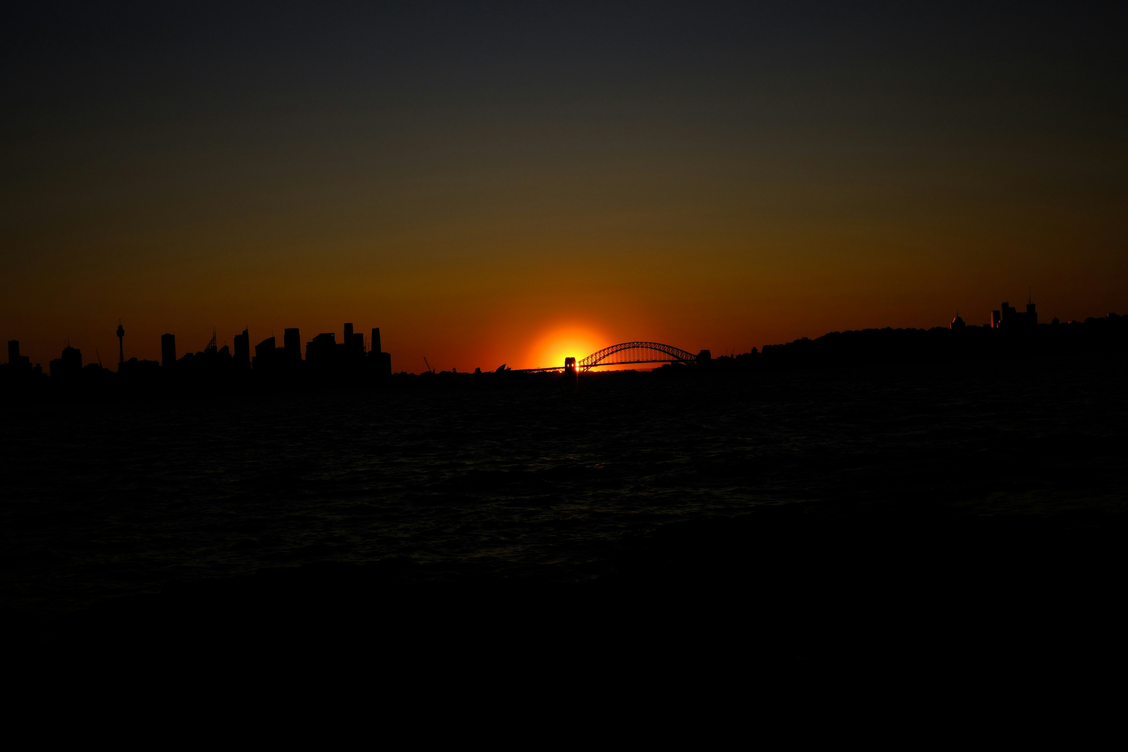 The sun is setting over the horizon of a city